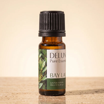 Delune Bay Laurel Pure Essential Oil, 10ml amber glass bottle on warm travertine stone