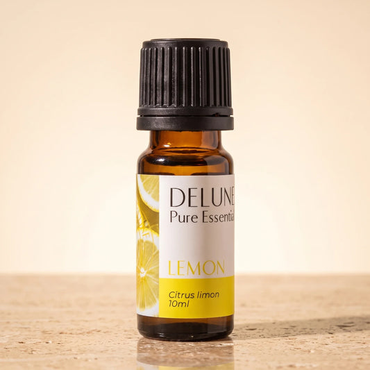 Delune Lemon Pure Essential Oil, 10ml amber glass bottle on warm travertine stone