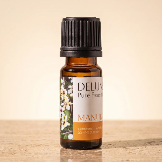 Delune Mānuka Pure Essential Oil, 10ml amber glass bottle on warm travertine stone