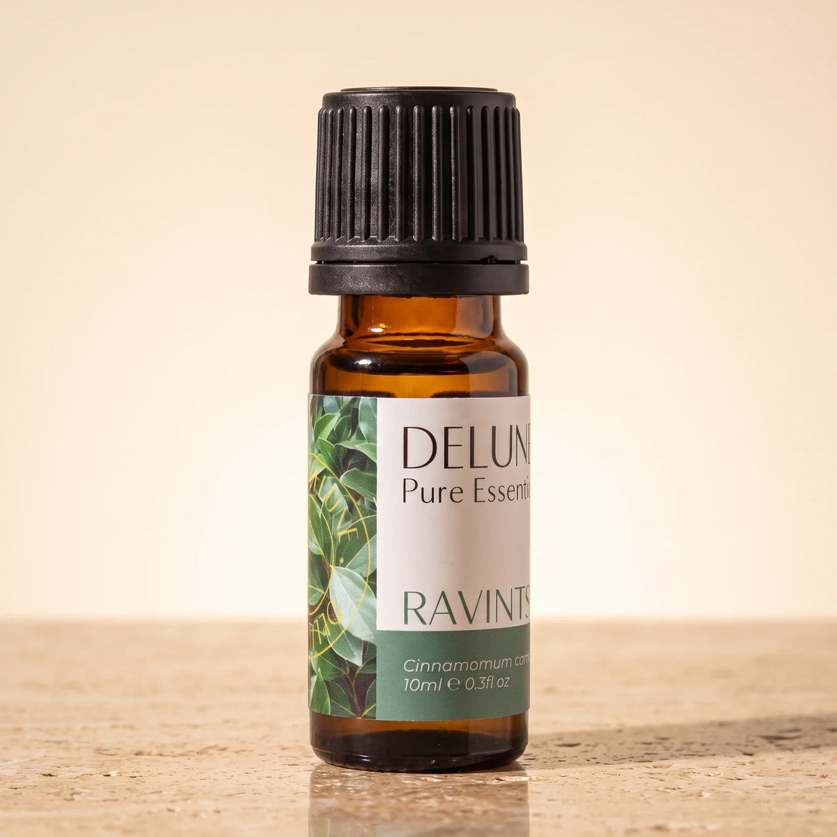 Delune Ravintsara Pure Essential Oil, 10ml amber glass bottle on warm travertine stone