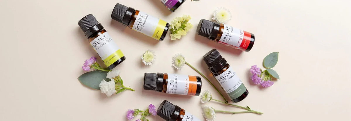 Delune essential oil bottles laid out with fresh flowers and eucalyptus
